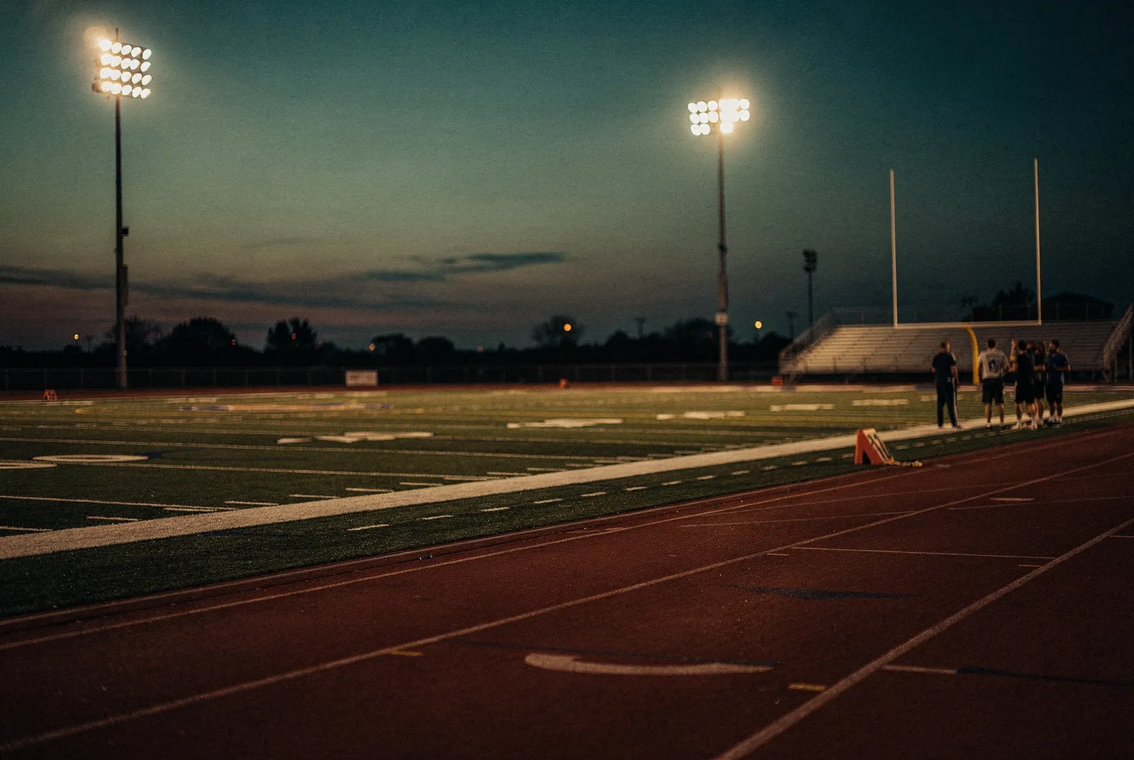 Riverbend's athletic field and track lit for an evening under the stadium lights